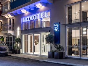 A hotel with a prominent 'NOVOTEL' sign, large glass windows, and a modern facade. - Novotel Malta Sliema (Gzira)