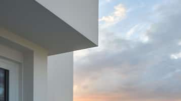 A modern building with a large glass window and a view of the sky.