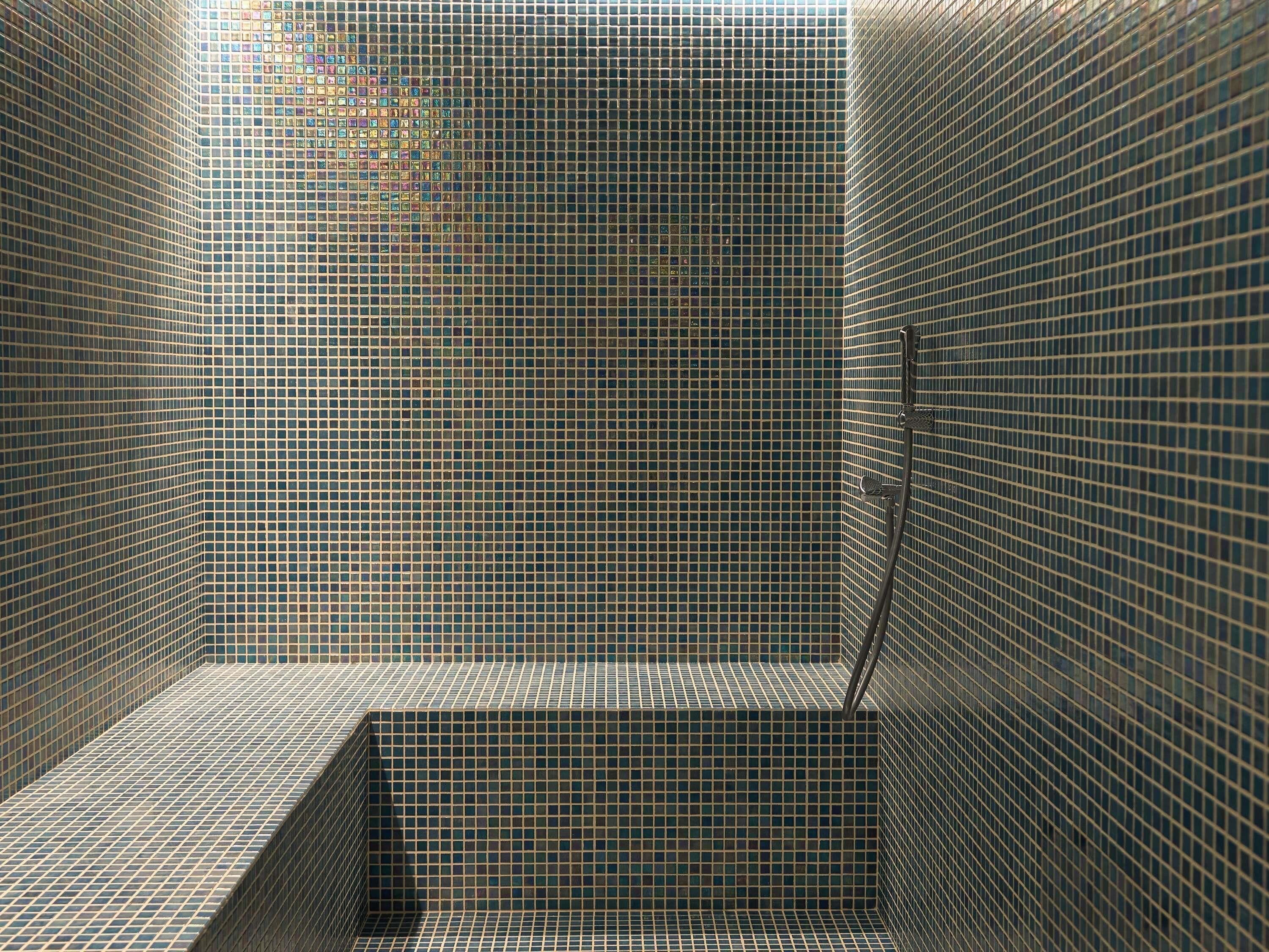 Un box de ducha con azulejos y un diseño de cuadrícula.