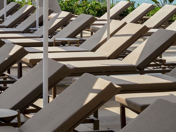 Rows of sun loungers with a view of greenery and a clear sky. - Novotel Malta Sliema (Gzira)