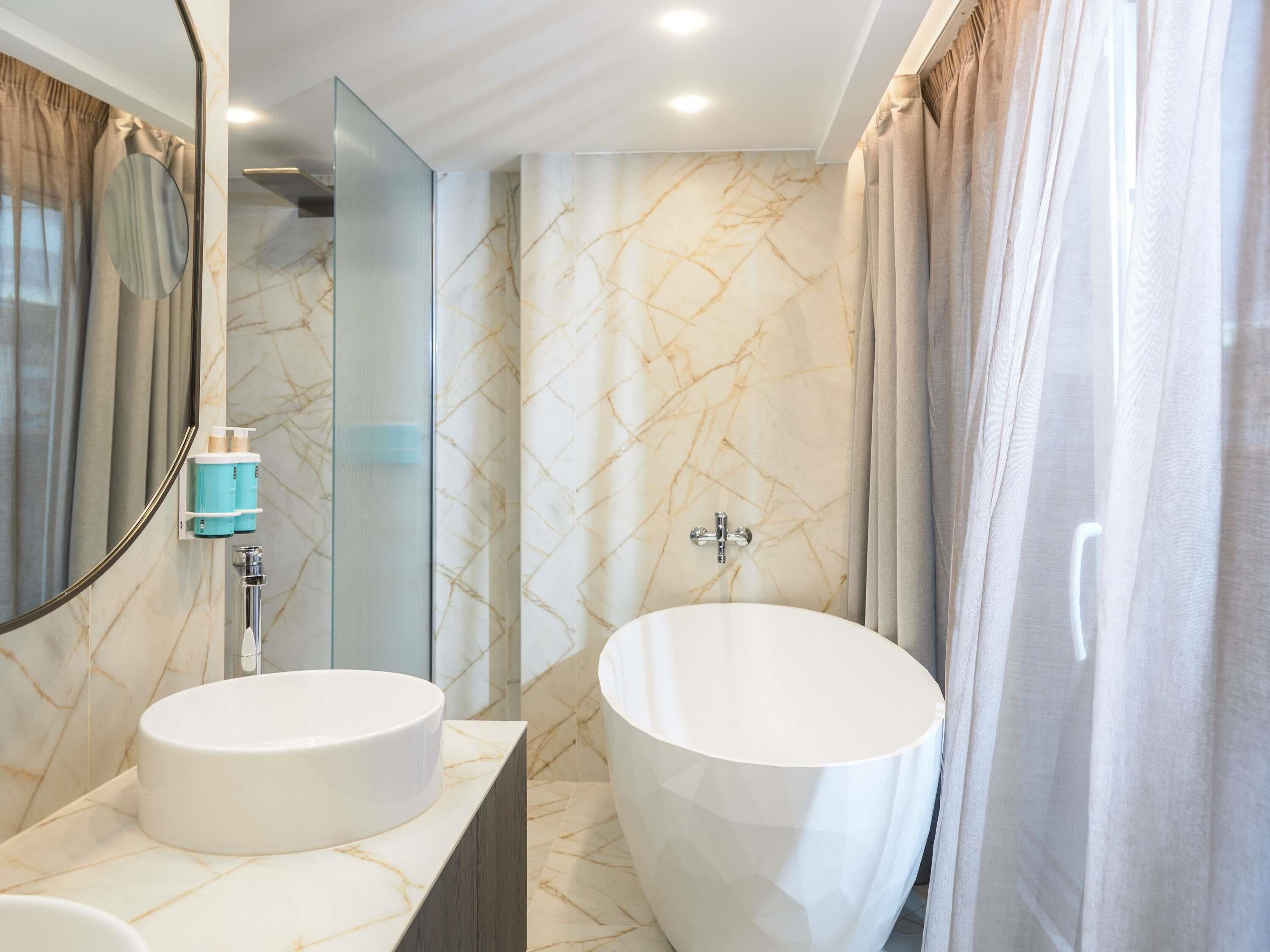 Une salle de bain avec deux lavabos, une grande baignoire et un miroir.