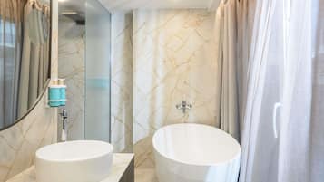 Une salle de bain avec deux lavabos, une grande baignoire et un miroir.