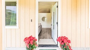 Uma casa de madeira com uma porta que dá para um cômodo interno.