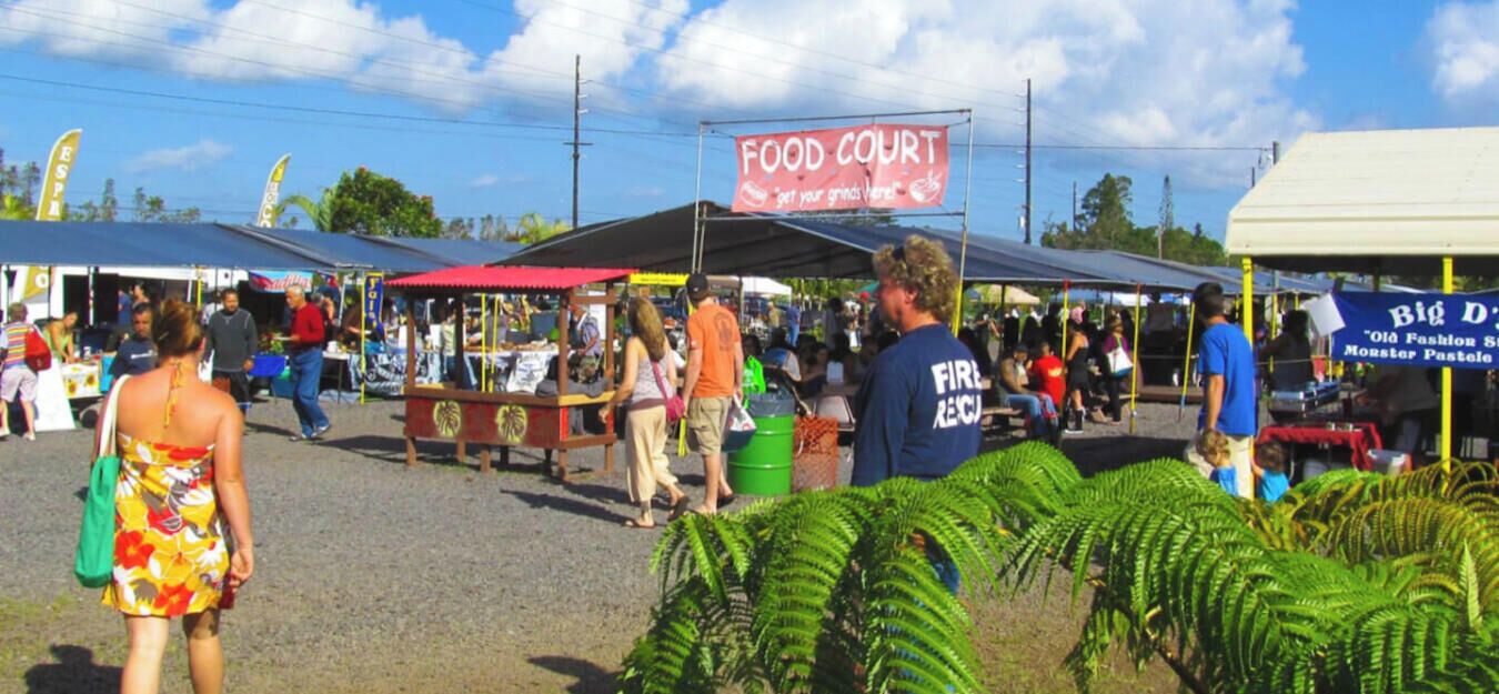 Un mercato con diversi banchi e un cartello che indica 'FOOD COURT'.