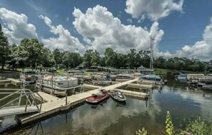 Boats docked at the marina, surrounded by trees.