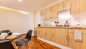 A modern kitchen with wooden cabinets, a dining table with chairs, and a countertop with kitchen appliances. - Polanco Studio Near Chapultepec Park & Museums (Ciudad de México)