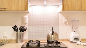 A kitchen with a gas stove, kettle, blender, and a grid-patterned backsplash. - Polanco Studio Near Chapultepec Park & Museums (Ciudad de México)