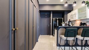 A modern kitchen with a central island, bar stools, and a built-in oven. - Stylish Reforma Loft w/Pool, Gym, AC & City Views (Ciudad de México)
