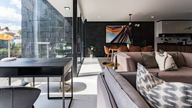 Una sala de estar moderna con un sofá, un comedor y una cocina.