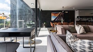 Una sala de estar moderna con un sofá, un comedor y una cocina visibles en un espacio abierto.