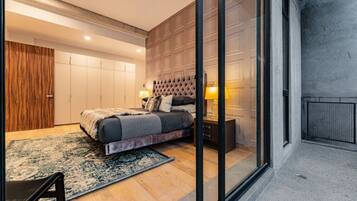 Quarto moderno com uma cama grande, um guarda-roupa de madeira e uma porta de vidro para uma varanda.
