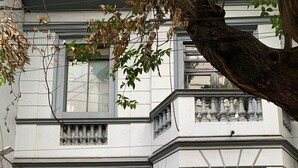 A building with a large, ornate metal gate and a wooden window with decorative iron bars. - Chillout Roma Vibes, Ping Pong, Walk to Top Bars (Ciudad de México)