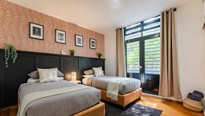 A double room with two beds, a large window with curtains, and a patterned wall. - Chillout Roma Vibes, Ping Pong, Walk to Top Bars (Ciudad de México)