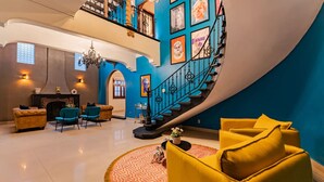 A spacious living area with a grand staircase, a fireplace, and a round coffee table. - Ideal for Groups, Rooftop, BBQ, Walk to Reforma (Ciudad de México)