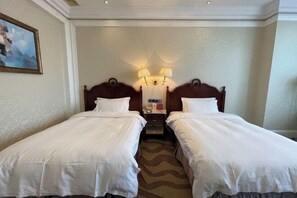 A hotel room with two single beds, a nightstand with a lamp, and a painting on the wall. - Liaobin Paxton Vacances Hotel Panjin (Panjin)