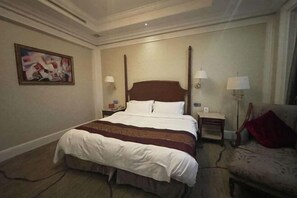 A hotel room with a large bed, two bedside tables with lamps, a chair, and a painting on the wall. - Liaobin Paxton Vacances Hotel Panjin (Panjin)