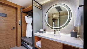 A modern bathroom with a wooden vanity, a round mirror with a light, and a built-in shower. - Mercure Guangzhou Baiyun International Airport (Guangzhou)