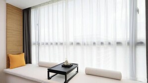 A room with a window seat, a small table, and a cushion. - Mercure Guangzhou Baiyun International Airport (Guangzhou)