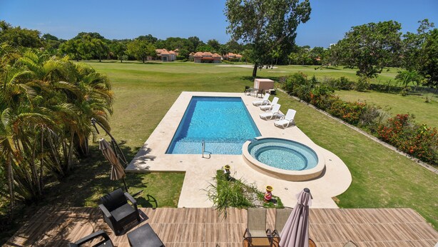 A swimming pool with lounge chairs and a hot tub, surrounded by a well-maintained lawn and tropical plants. - Beautiful vacation home in Costa Blanca Golf & Villas by Decameron. (Rio Hato)