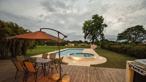 An outdoor patio with a pool, a grill, and a table with chairs. - Beautiful vacation home in Costa Blanca Golf & Villas by Decameron. (Rio Hato)