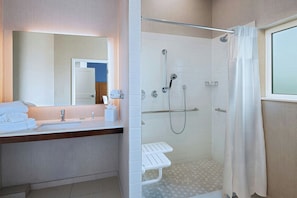 Une salle de bain moderne avec une douche à parois de verre, un meuble-lavabo avec un miroir et un porte-serviettes.
