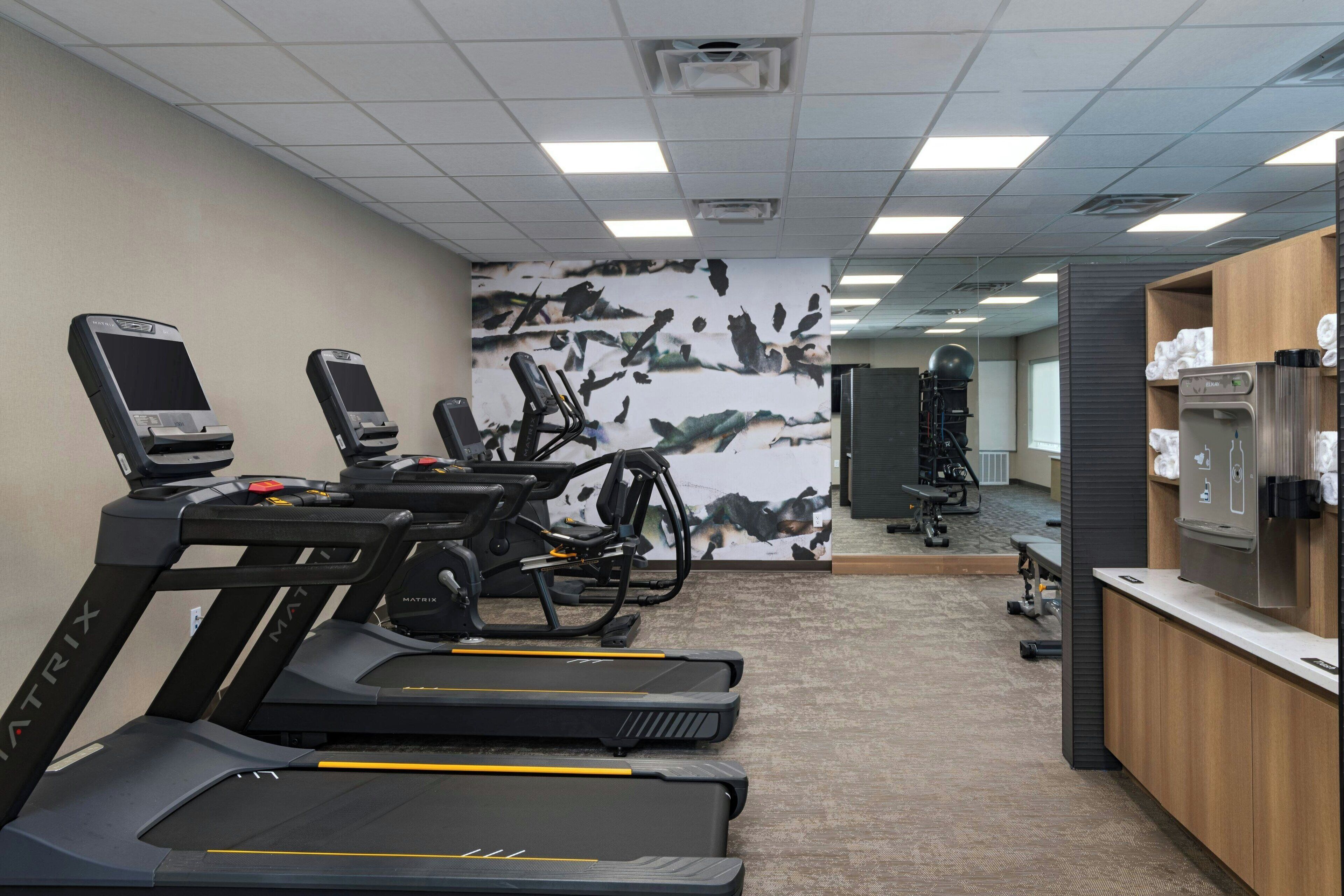 A gym with treadmills, stationary bikes, and a weight machine.