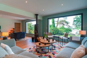 A spacious living room with a large window, a fireplace, and comfortable seating. - Le Rivage de Carnac - Vue mer, proche plage (Carnac)