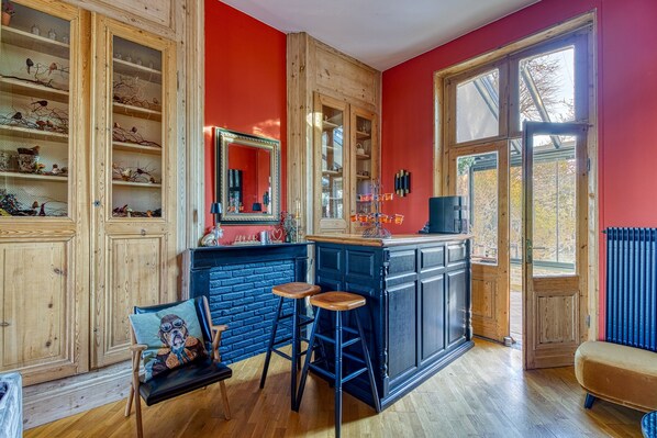 A kitchen with wooden cabinets, a blue bar area, and a large window.