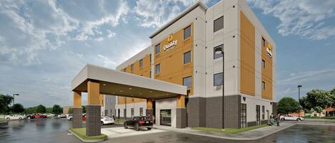A modern hotel with a covered entrance, multiple floors, and a parking lot.
