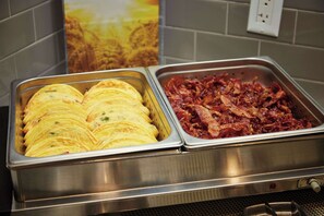 A buffet with omelettes and bacon.