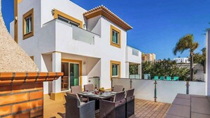 En modern villa med en uteplats, utomhusmöbler och utsikt över det omgivande området.