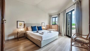 Una camera da letto con un letto, comodini, una sedia e una finestra con tende.