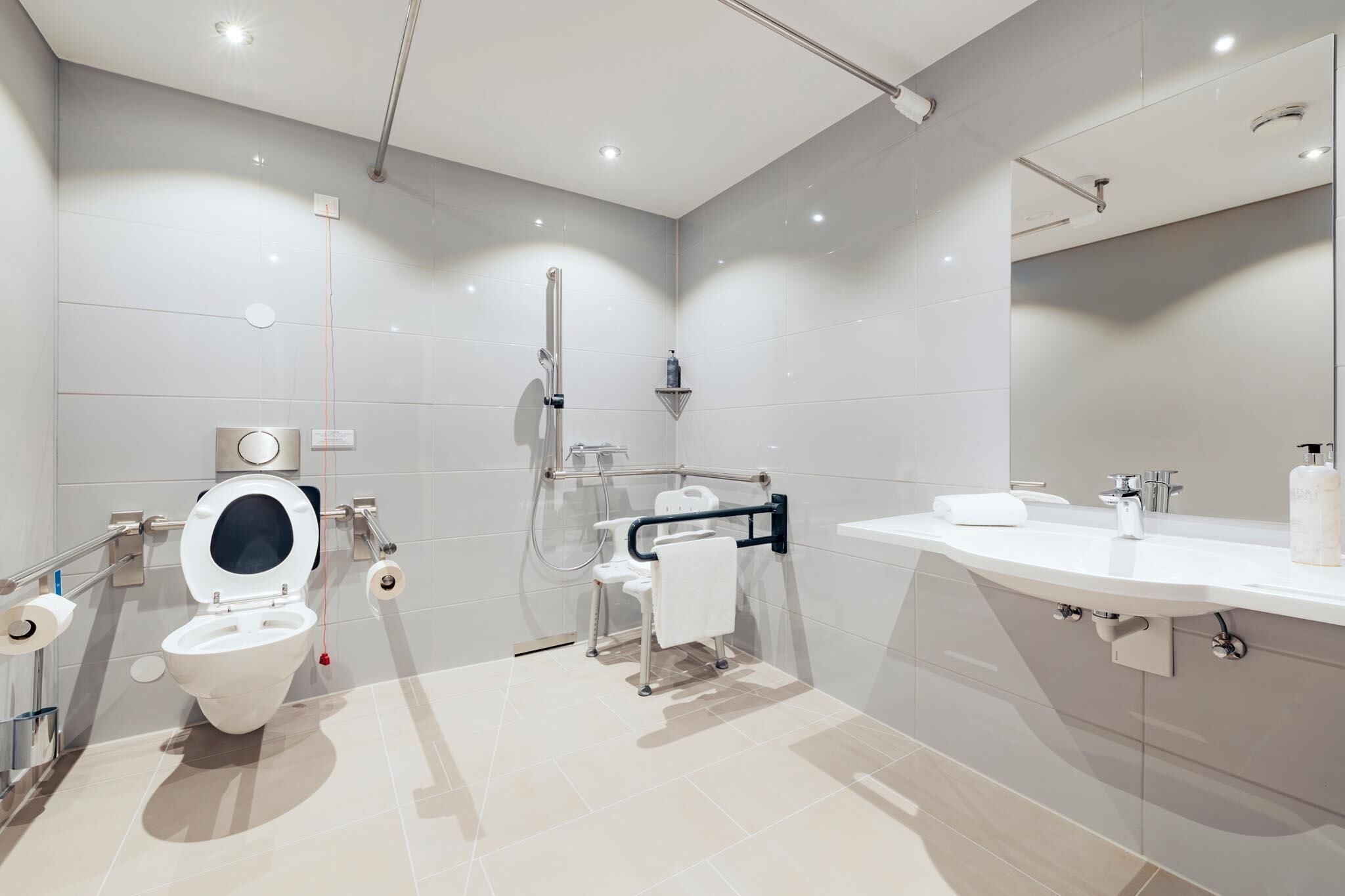 Un baño moderno con inodoro, ducha y lavamanos.