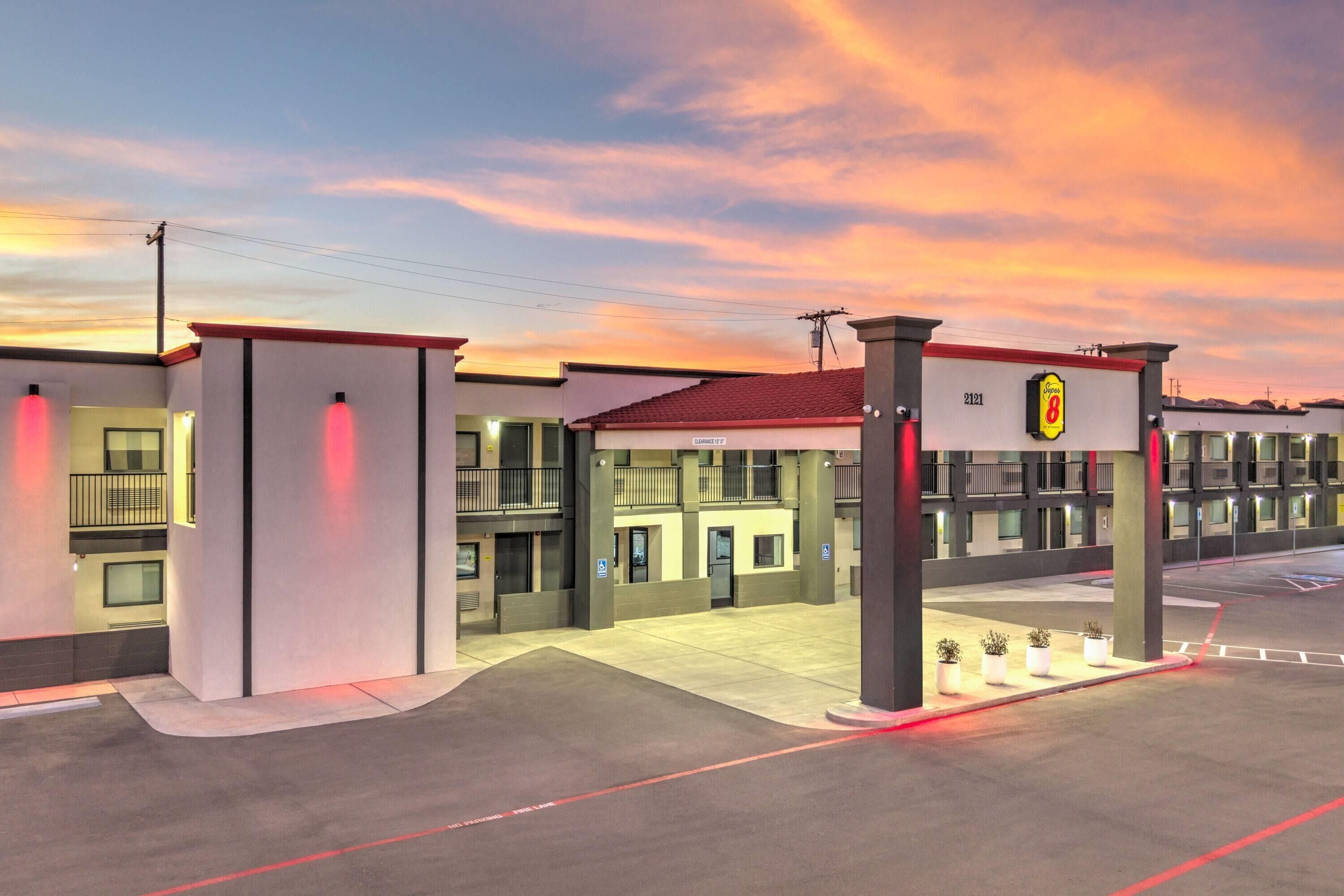L’entrée d’un hôtel, reconnaissable à son toit rouge, à ses nombreux étages et à son espace de stationnement.