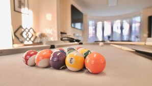 A pool table with colorful billiard balls arranged in a line.