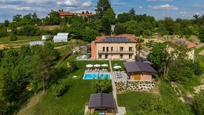 Ein großes Haus mit Swimmingpool, Solaranlage und Garten.