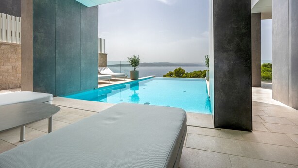 A modern outdoor pool area with a clear view of the sea, lounge chairs, and a potted plant. - Villa Rora - Four Bedroom Villa, Sleeps 8 (Brela - Krug)