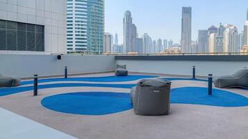 Une terrasse sur le toit, dotée d’espaces aménagés pour s’asseoir et offrant une vue panoramique sur la ville.