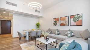 A modern living room with a sofa, coffee table, and dining area.