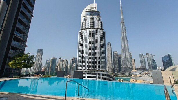 Ein modernes Hochhaus mit einem Pool im Vordergrund.