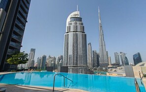 A modern high-rise building with a pool in the foreground. - Vogue, Downtown Boulevard Point Direct access to Dubai Mall (Dubai)