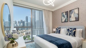 Ein modernes Hotelzimmer mit einem großen Bett, Blick auf die Stadt, einer dekorativen Vase und abstrakter Kunst an der Wand.