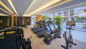 A gym with treadmills, a stationary bike, and weight machines. - Vogue, JVC Luma22 East near Circle Mall (Dubai)
