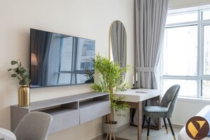 Relax in a serene space with a large flat-screen TV, comfortable chair, and a potted plant.