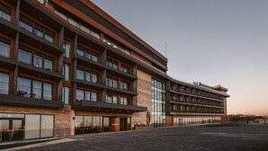 A modern hotel with multiple floors, large windows, and a prominent entrance. - BODBE Hotel (Sighnaghi)