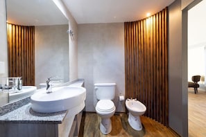 A modern bathroom with a large sink, two toilets, and wooden paneling. - CABAÑAS RUCA TAMI (El Calafate)