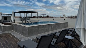 A rooftop pool area with a hot tub, lounge chairs, and a covered seating area. - Bliss, in the heart of PV! 2-bedroom apartment with AC, WiFi in Puerto Vallarta (Puerto Vallarta)