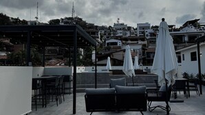 A rooftop terrace with outdoor seating, including a sofa and chairs, and umbrellas. - Bliss, in the heart of PV! 2-bedroom apartment with AC, WiFi in Puerto Vallarta (Puerto Vallarta)