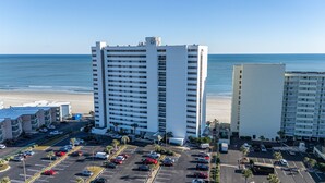 A high-rise hotel with multiple floors, a parking lot, and a beach view. - Upscale Oceanfront 3BR Condo • 14th Floor • Golf Course Views (Myrtle Beach)