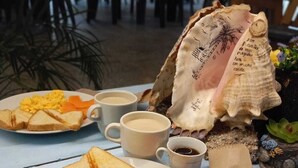 Une table mise pour le petit-déjeuner avec des toasts, des œufs brouillés et une grande coquille.